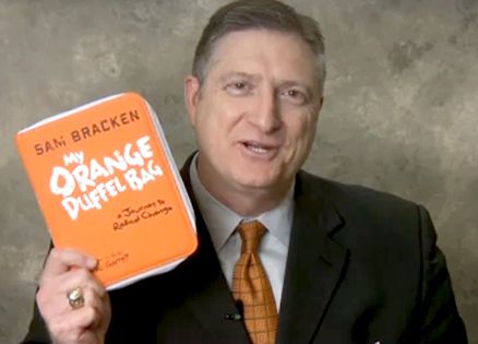 Sam Bracken holding his book that tells his inspiring story