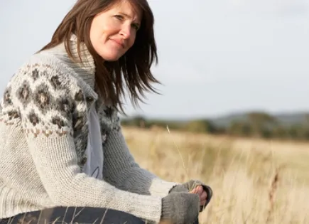 woman sitting outside in wheatfield