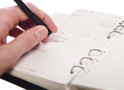 Person making a notation in a personal calendar