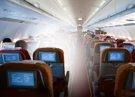 A view from the back of a plane with one seat emitting a heavenly glow