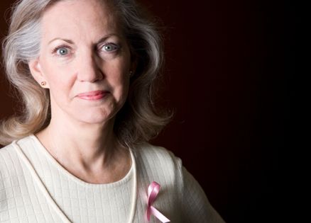 A mature breast cancer survivor smiles at the camera