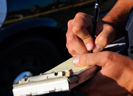 A man's hands writing a ticket