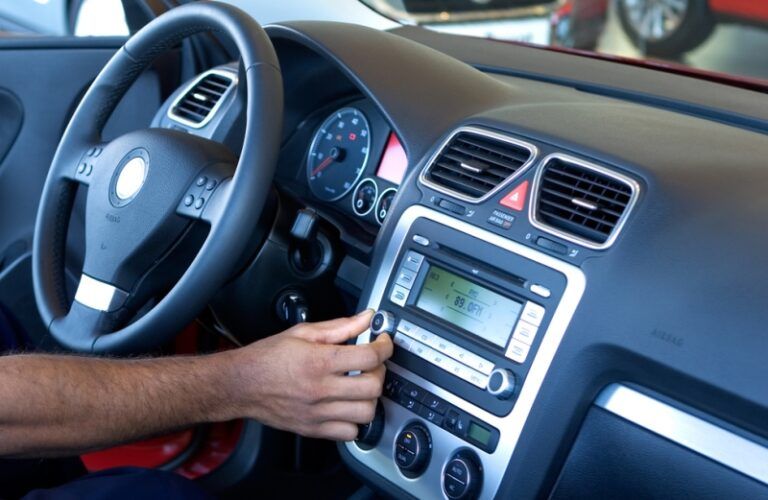 man changing the radio station in his car