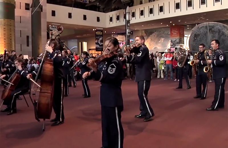 A flash mob composed of military musicians performs.