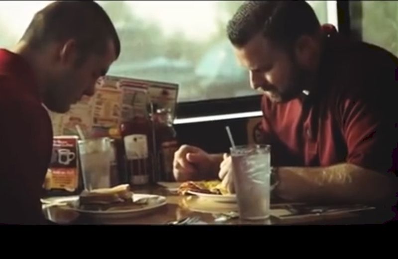 Two men pray over meal.