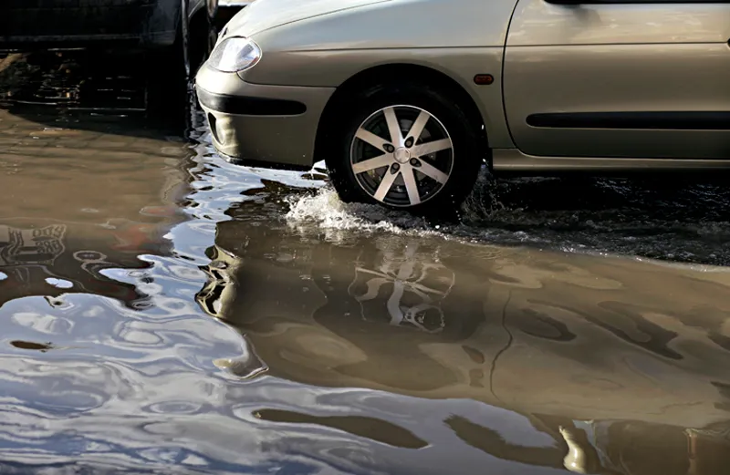 A car wades into a deep puddle.