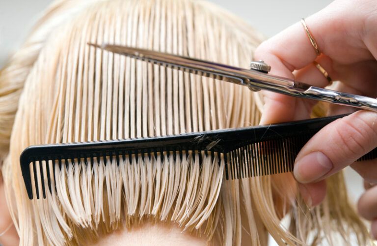 A woman seen from behind getting a short haircut