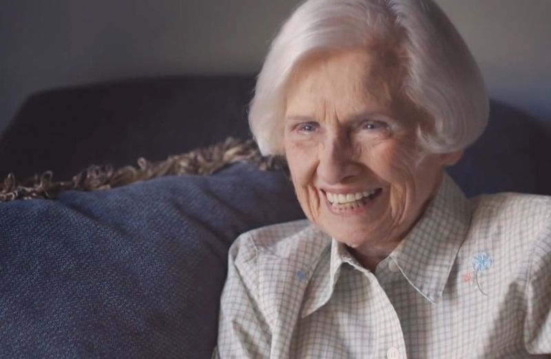 Old woman laughing on couch