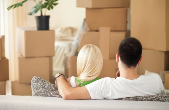 A couple looking at moving boxes in their new apartment.