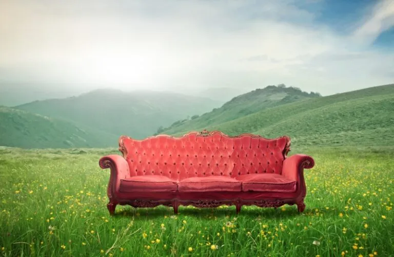 A couch in a beautiful outdoor setting with mountains in the background