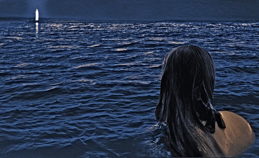 A woman treading water in the ocean gazes at a distant lighthouse.