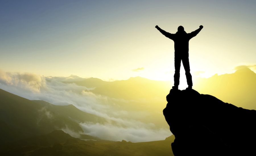 Man on a mountaintop. Thinkstock.