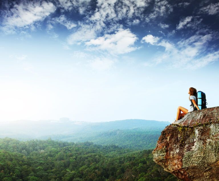 Woman sitting on edge of cliff