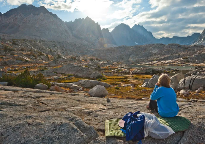 Guideposts: Rebekah perches on a rock to watch the sun setting over distant mountains