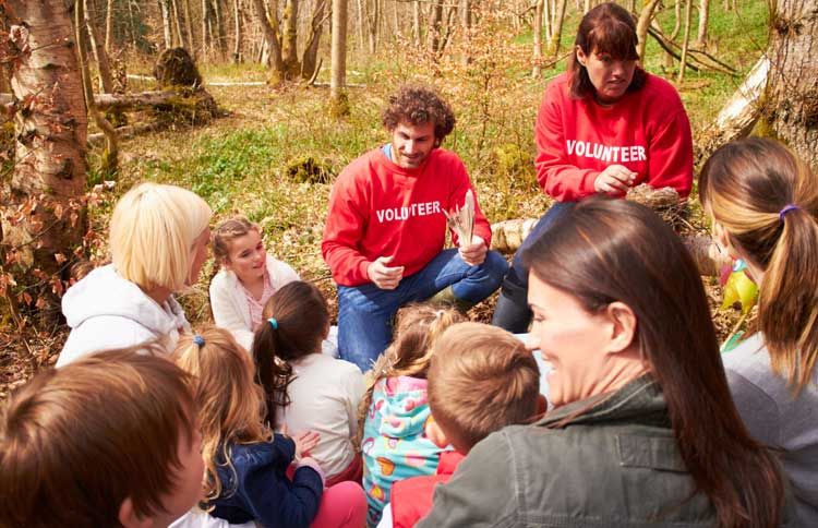 Guideposts: A pair of team leaders instruct a group of volunteers of all ages