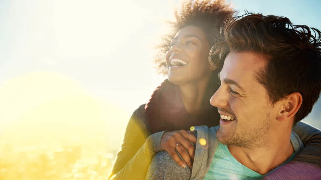 Newlyweds smiling in the sunshine after getting good advice