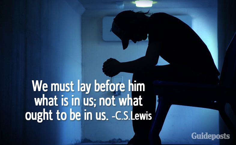 Man sitting in a dark room with C.S. Lewis quotes