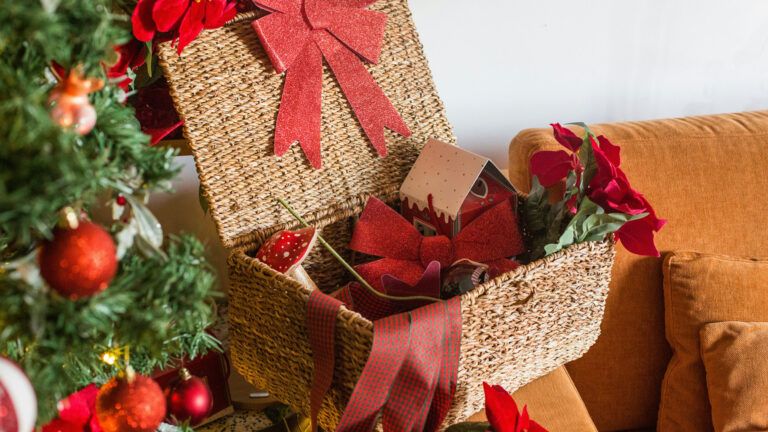 A wicker basket with poinsettias and holiday red ribbon. Photo credit: Unsplash