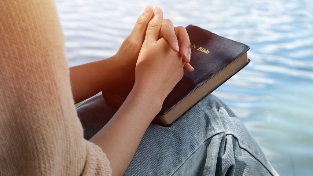 A woman says new year prayers over her Bible