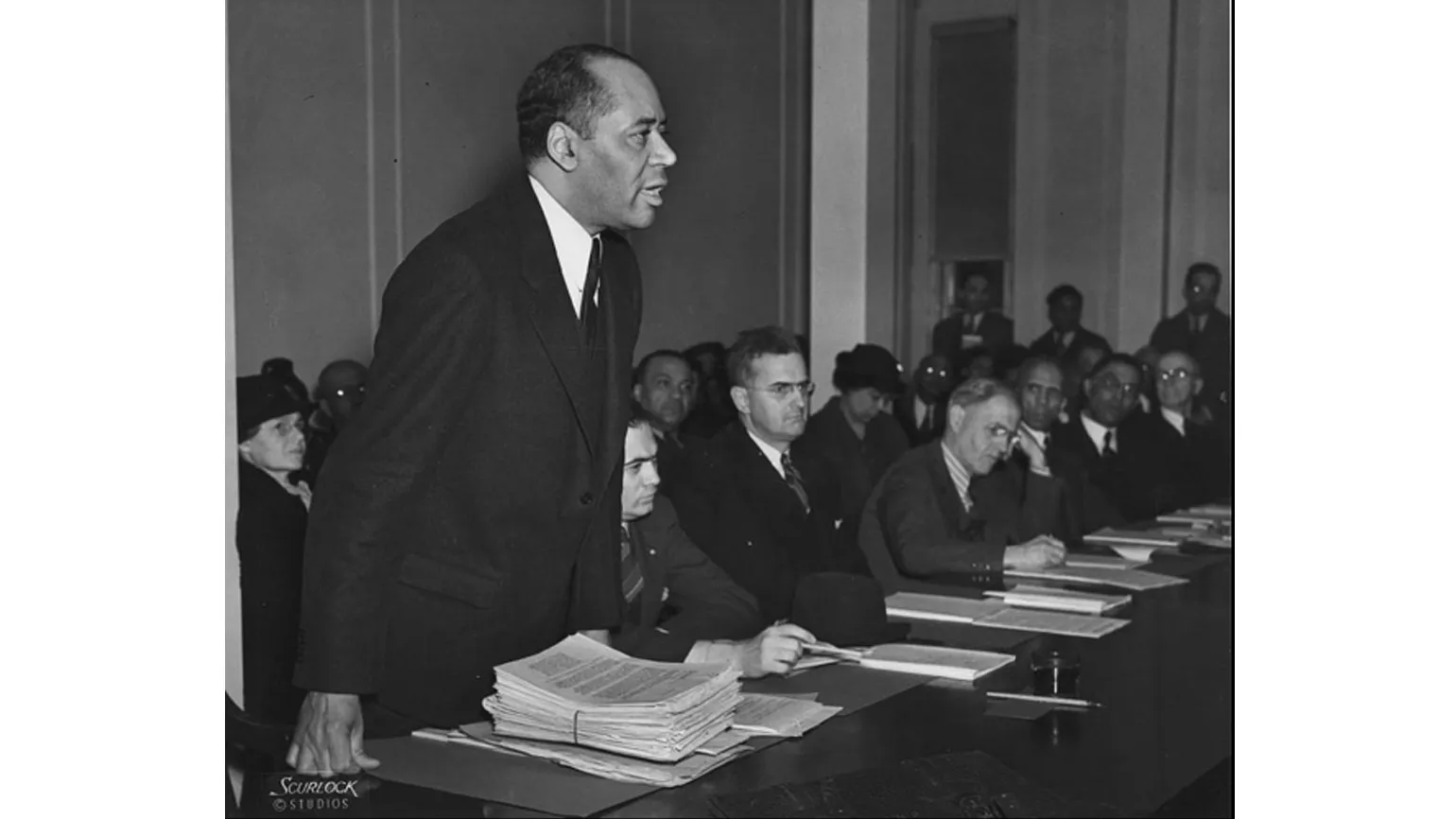 Charles Hamilton Houston stands at a table as an inspiring figure for Black History Month