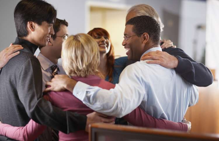 a circle of friends embracing and smiling