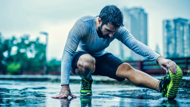 Man stretching in the rain