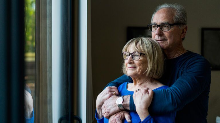 A mature married couple gaze contently out the window