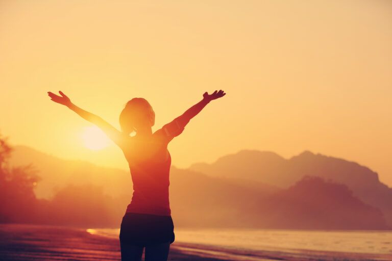 Woman at sunset listening to bible verses for strength as she exercises