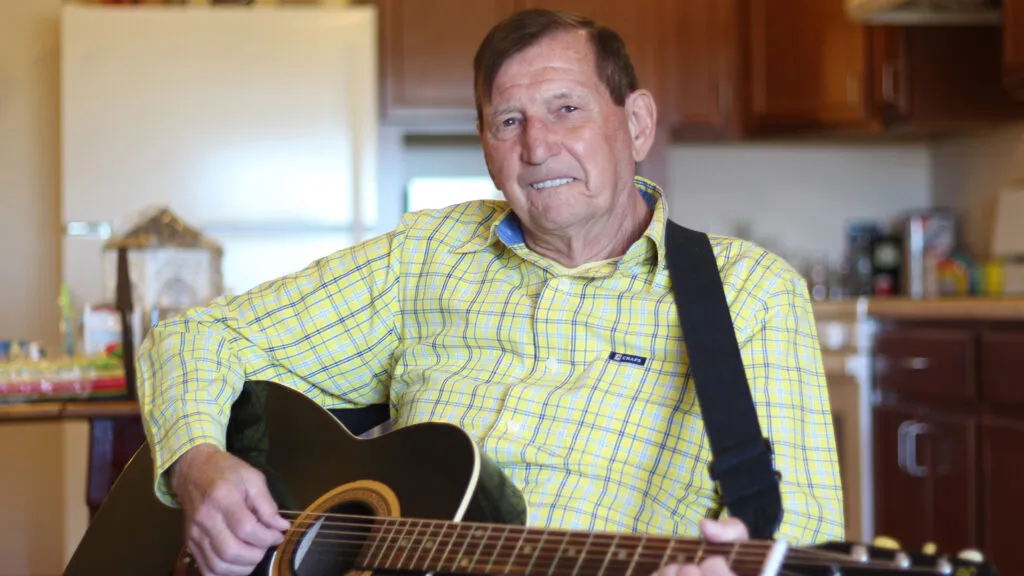 James Carlson in his apartment playing the guitar