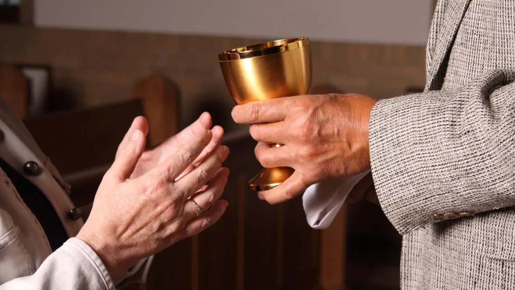 A daughter supports a mother at church.