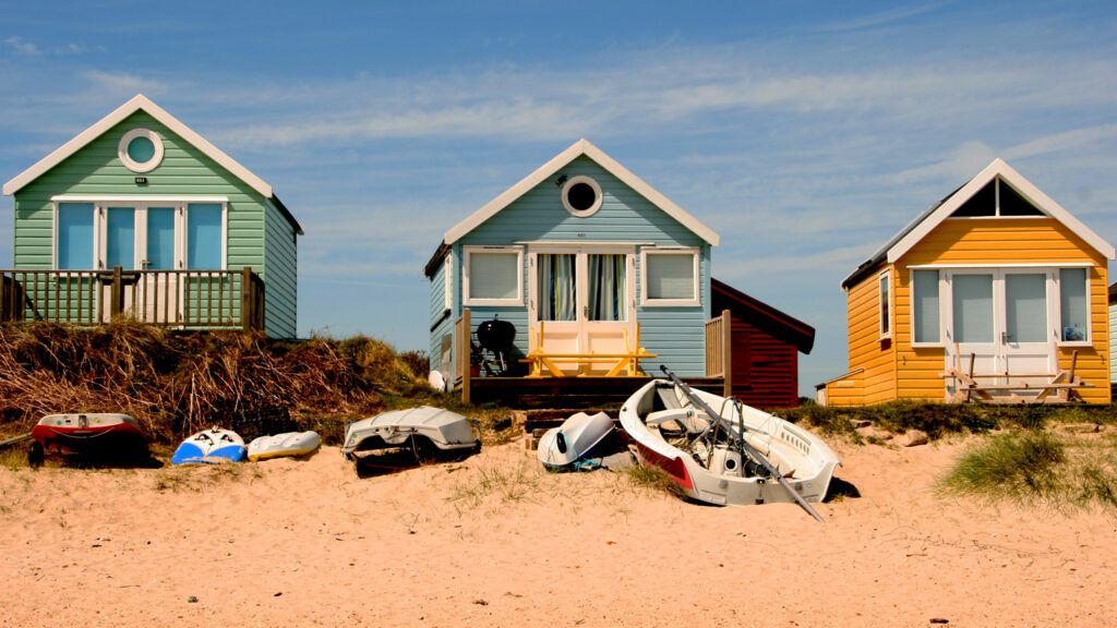 Three colorful beach houses lined up.