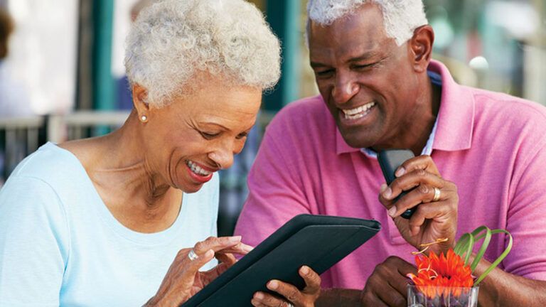 A mature couple use a tablet together