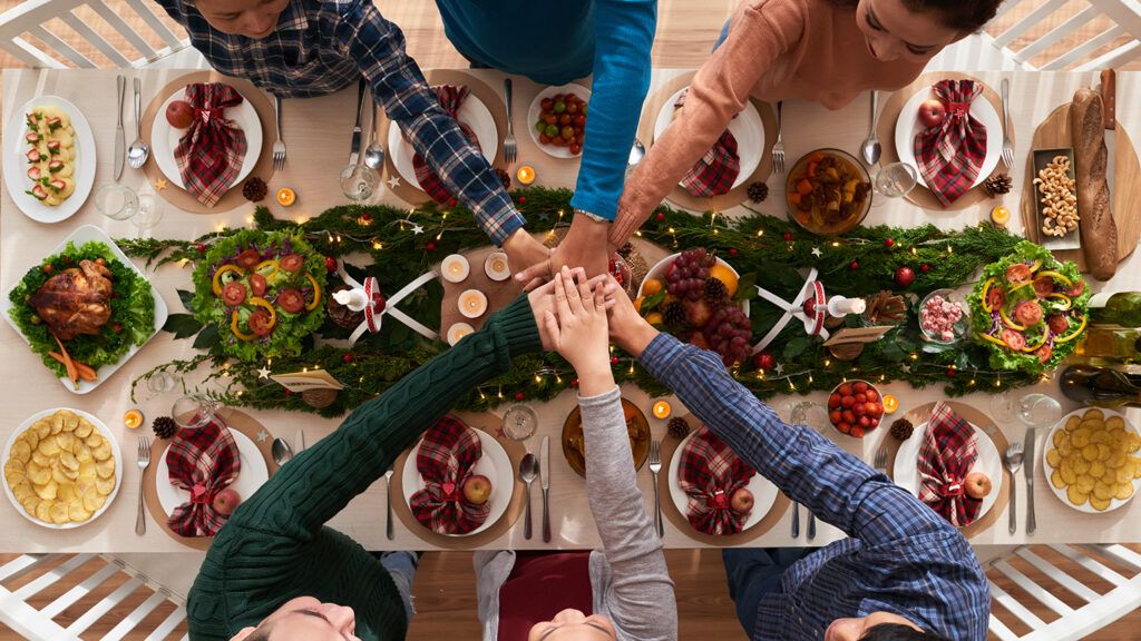 A family clasps hands at Christmas