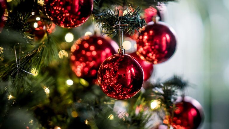 A Christmas tree festooned with shiny red ornaments