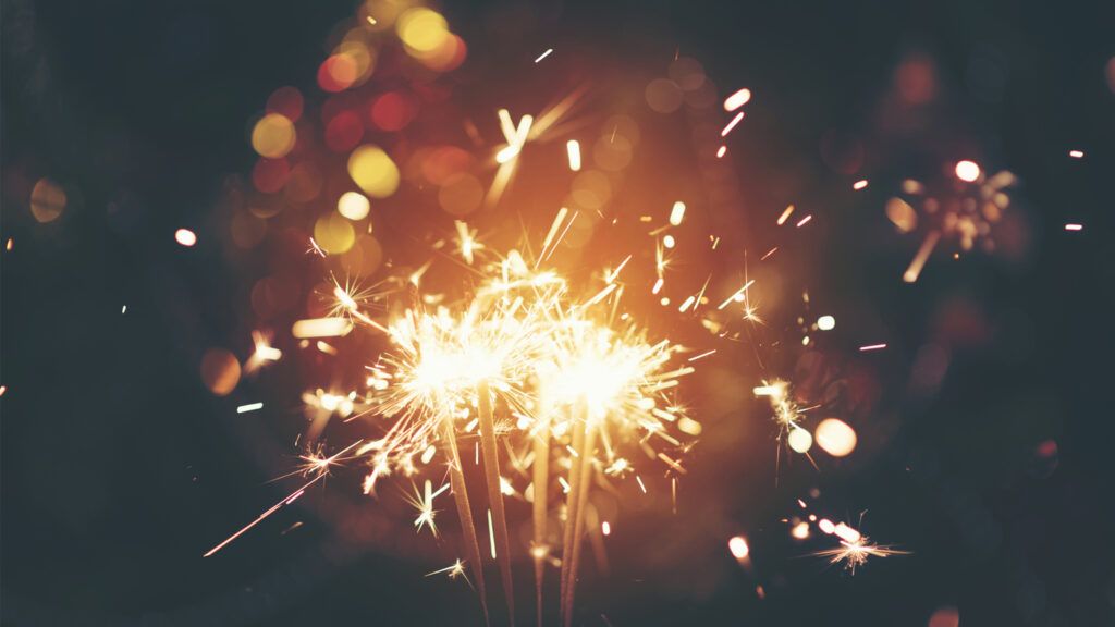 Sparklers with festive lights and bokeh.