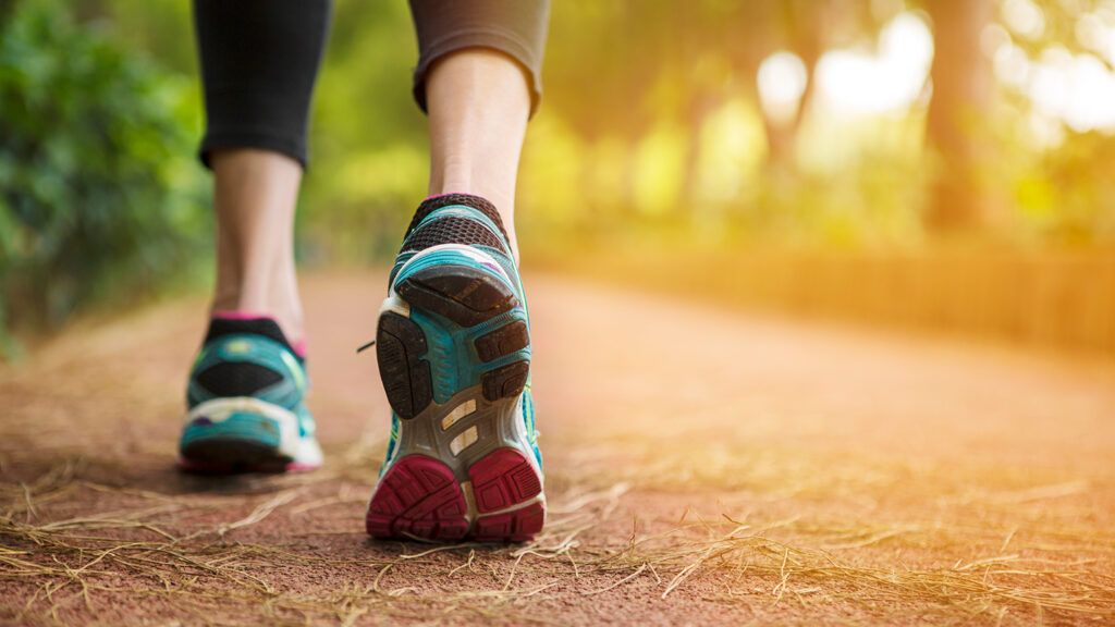 A woman walks for exercise on a jogging path