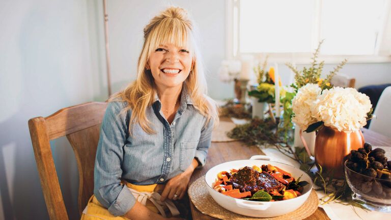 Bri sits at a kitchen table, her favorite pot roast at her side