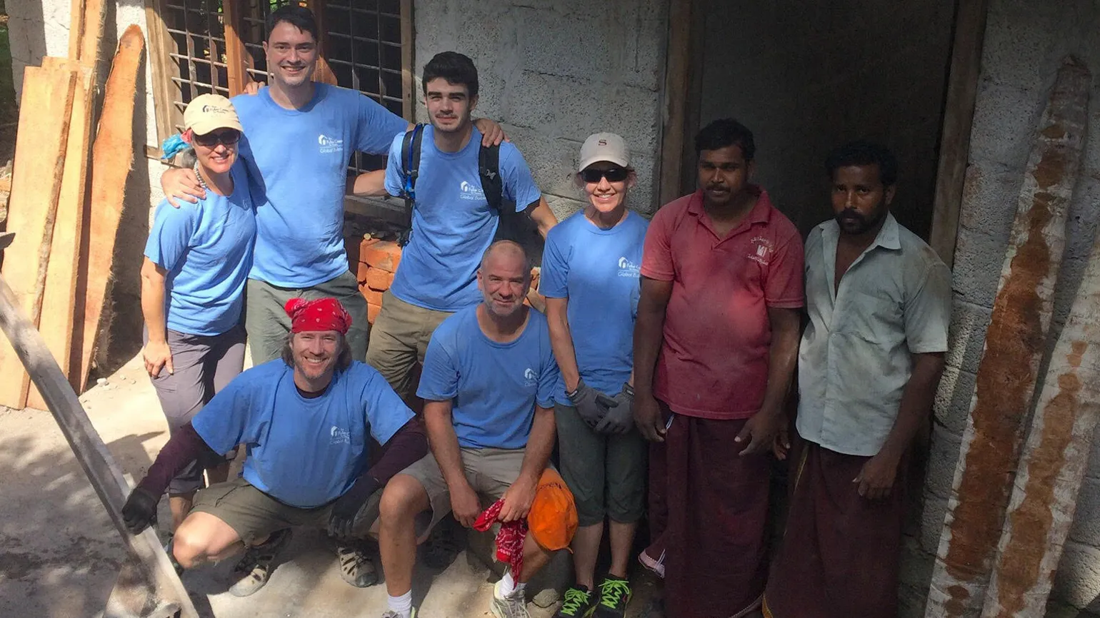 Doug and his mission trip team get ready to build houses in blue volunteer uniforms.