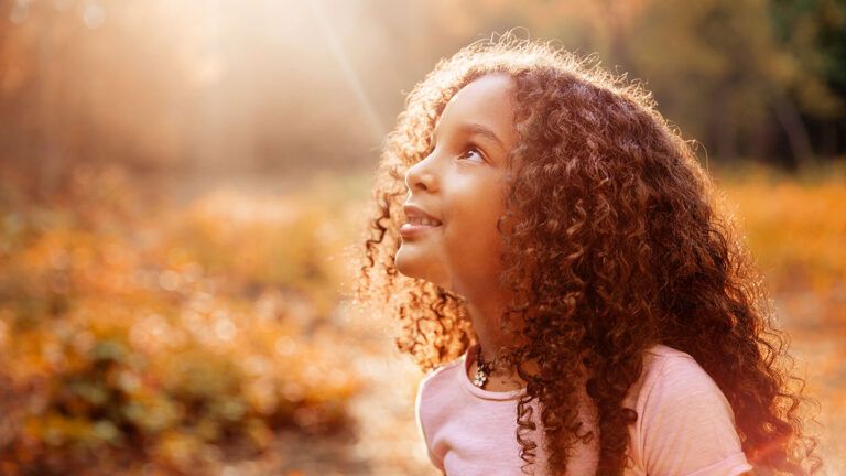 A smiling child looks upward