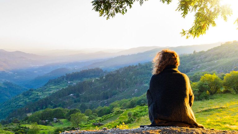 A woman gazes serenely out at a scenic vista