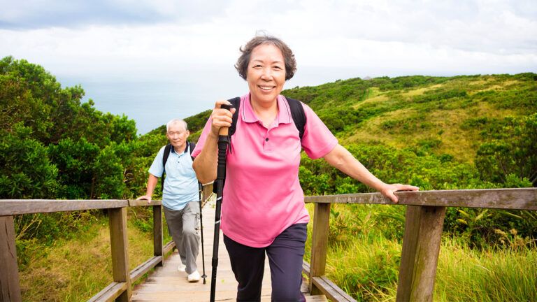 A woman smiles as she climbs a stairway in the mountains