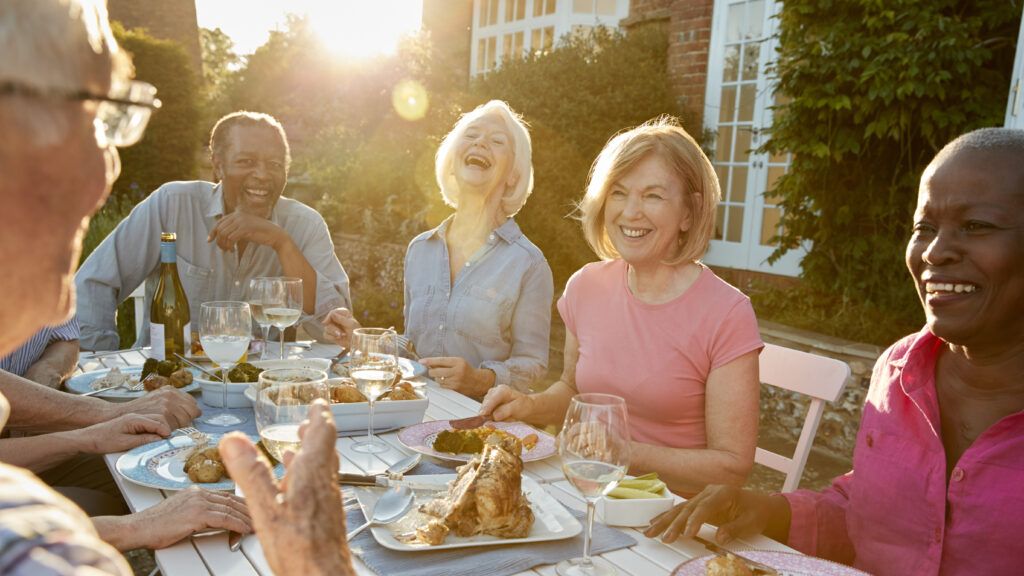 Group of friends laughing around a dinner table