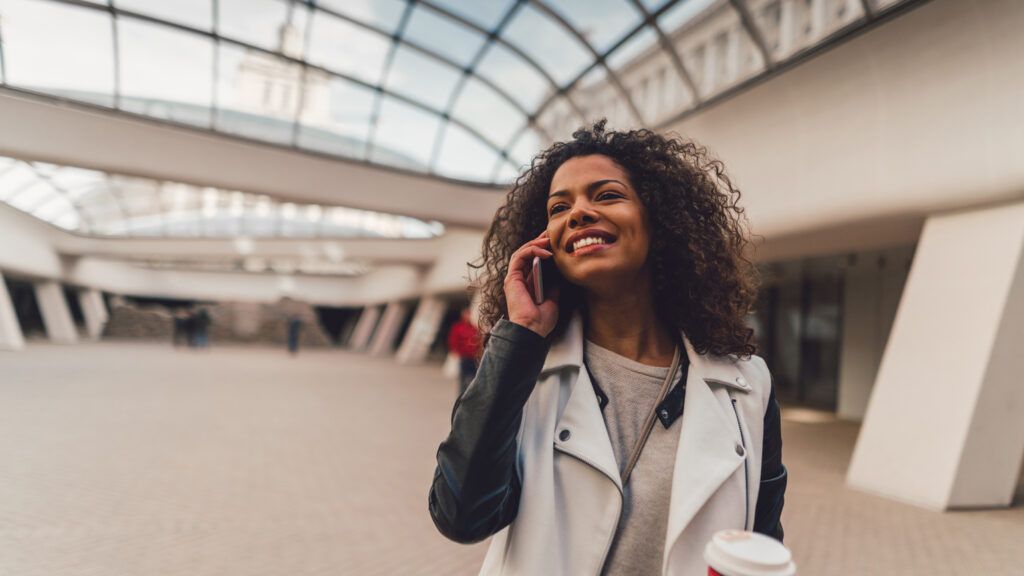 Mixed race woman enjoying a phone call in the subway station.