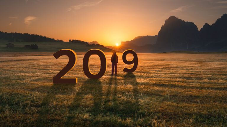 A woman in a field greets the new year at sunrise