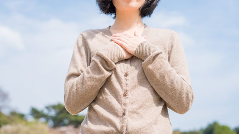 A woman, hands crossed over her heart, expresses gratitude