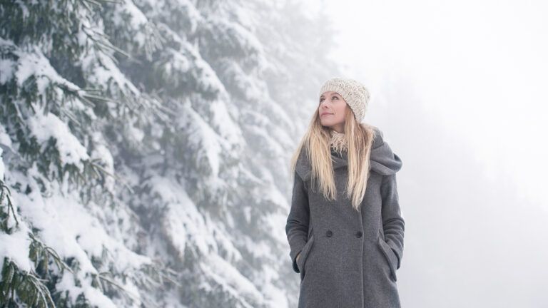 A woman gazes skyward during a winter stroll