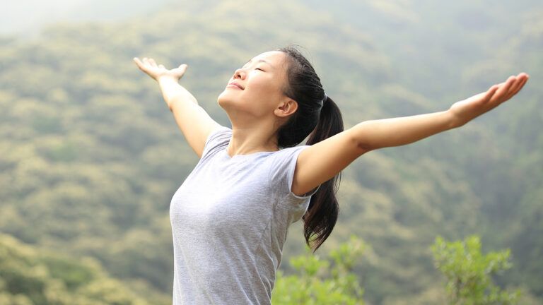 Woman with arms outstretched to the sun