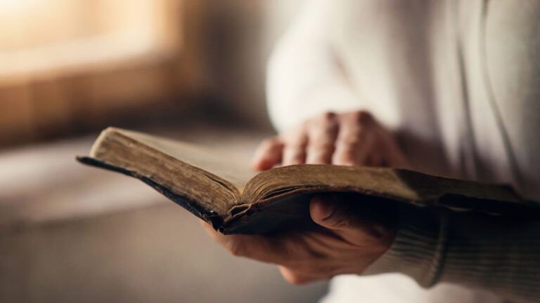 Woman reading spring prayers in her old Bible