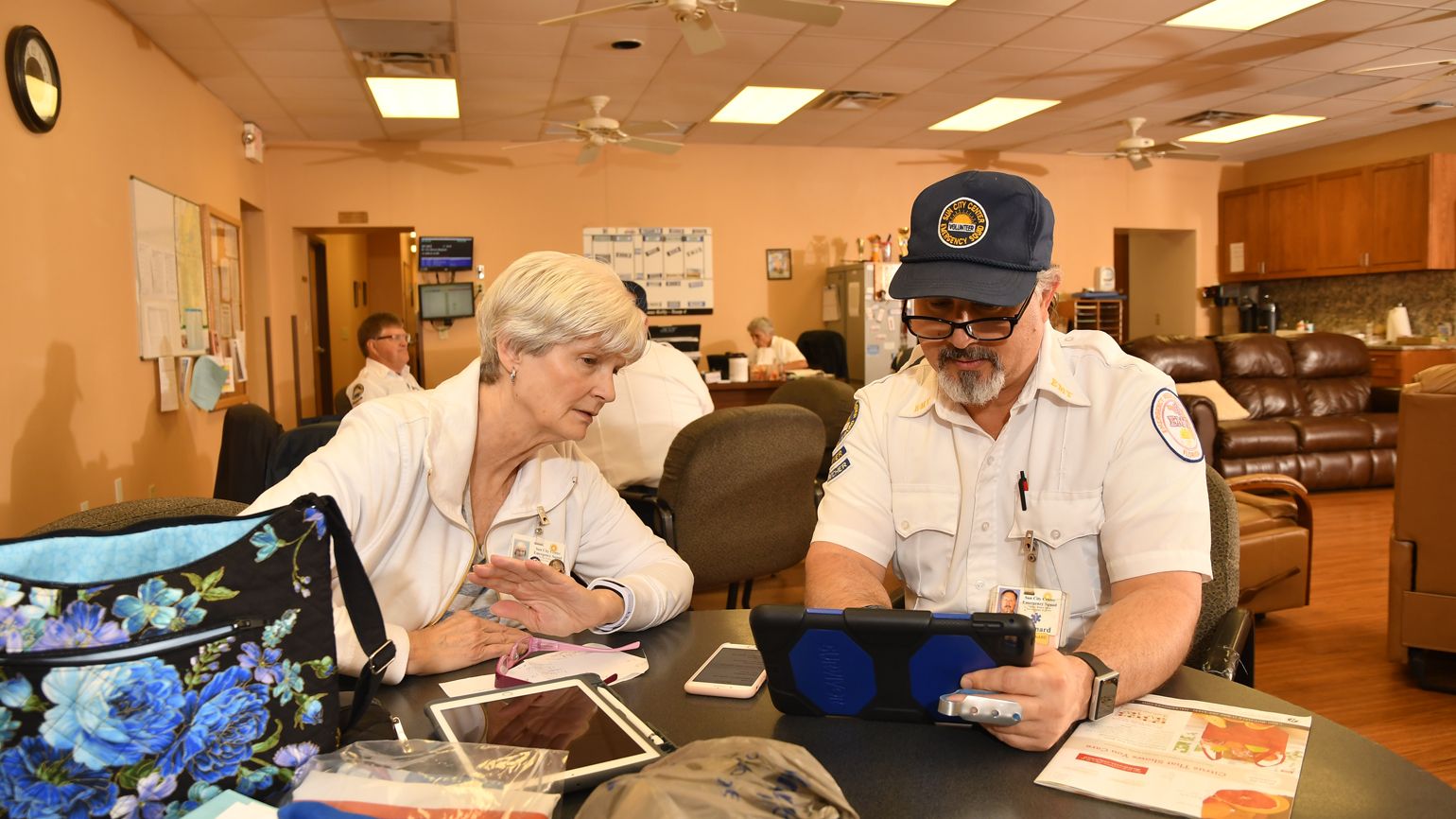 Captain Robert Leonard explains to a woman using an iPad.