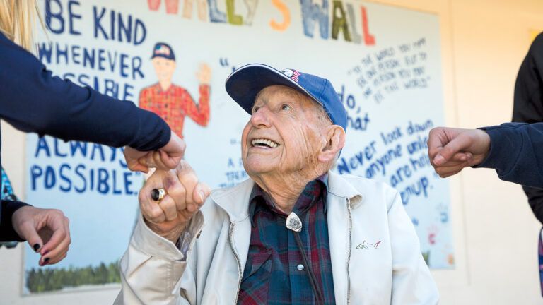 Wally Richardson fist-bumps some students